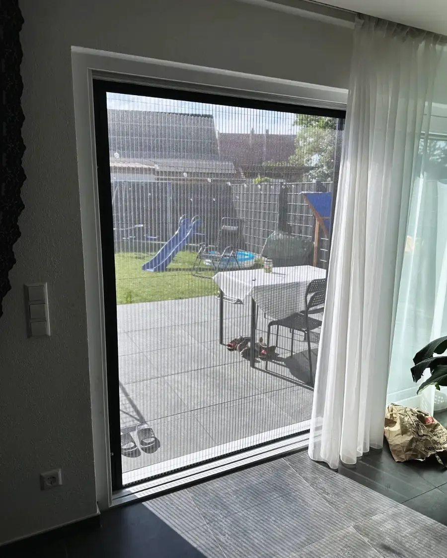 Insektenschutz an einer Terrassentür mit Blick in den Garten